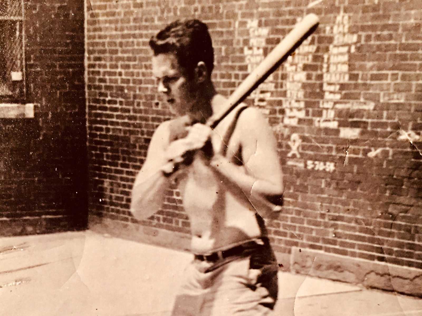 Teen in 20's shirtless holding baseball bat