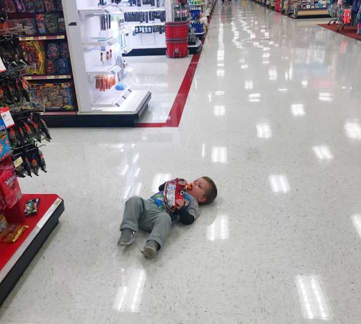 Toddler lies on floor of Target eating Doritos