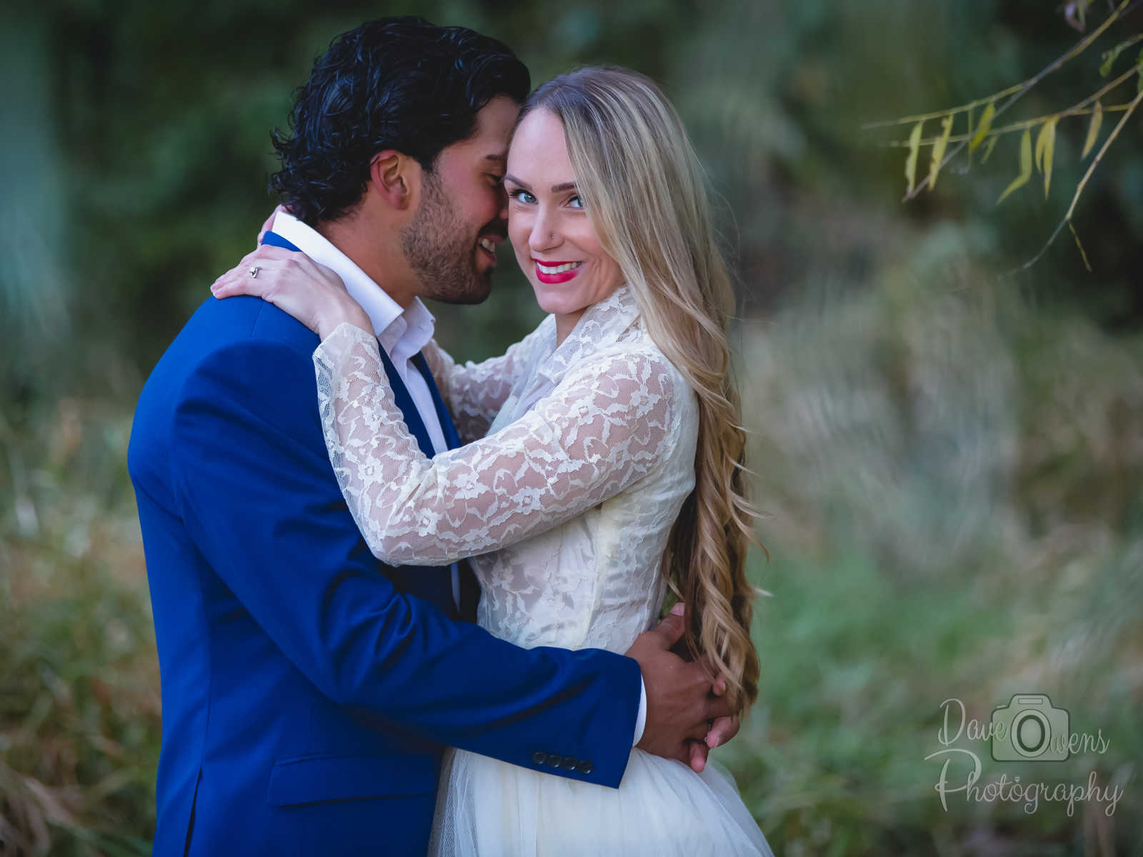 engaged couple in wedding attire wrapped in each others arms