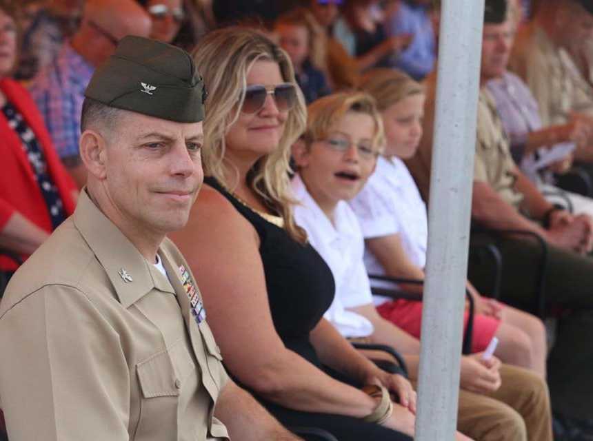 Marine husband and father sits in uniform with wife, son, and daughter
