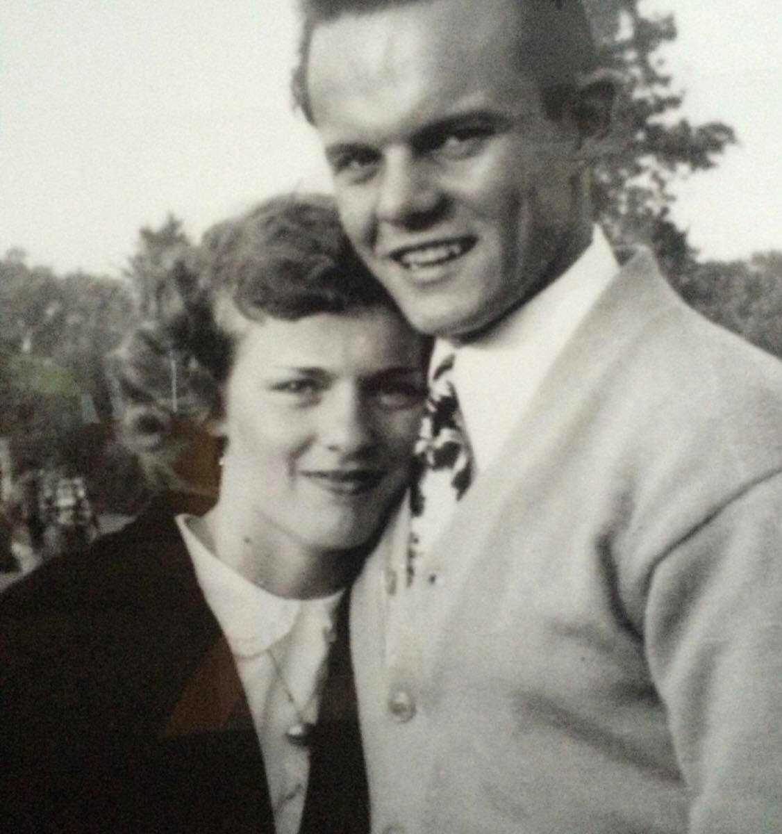 Woman with dementia leaning against husband's chest smilting