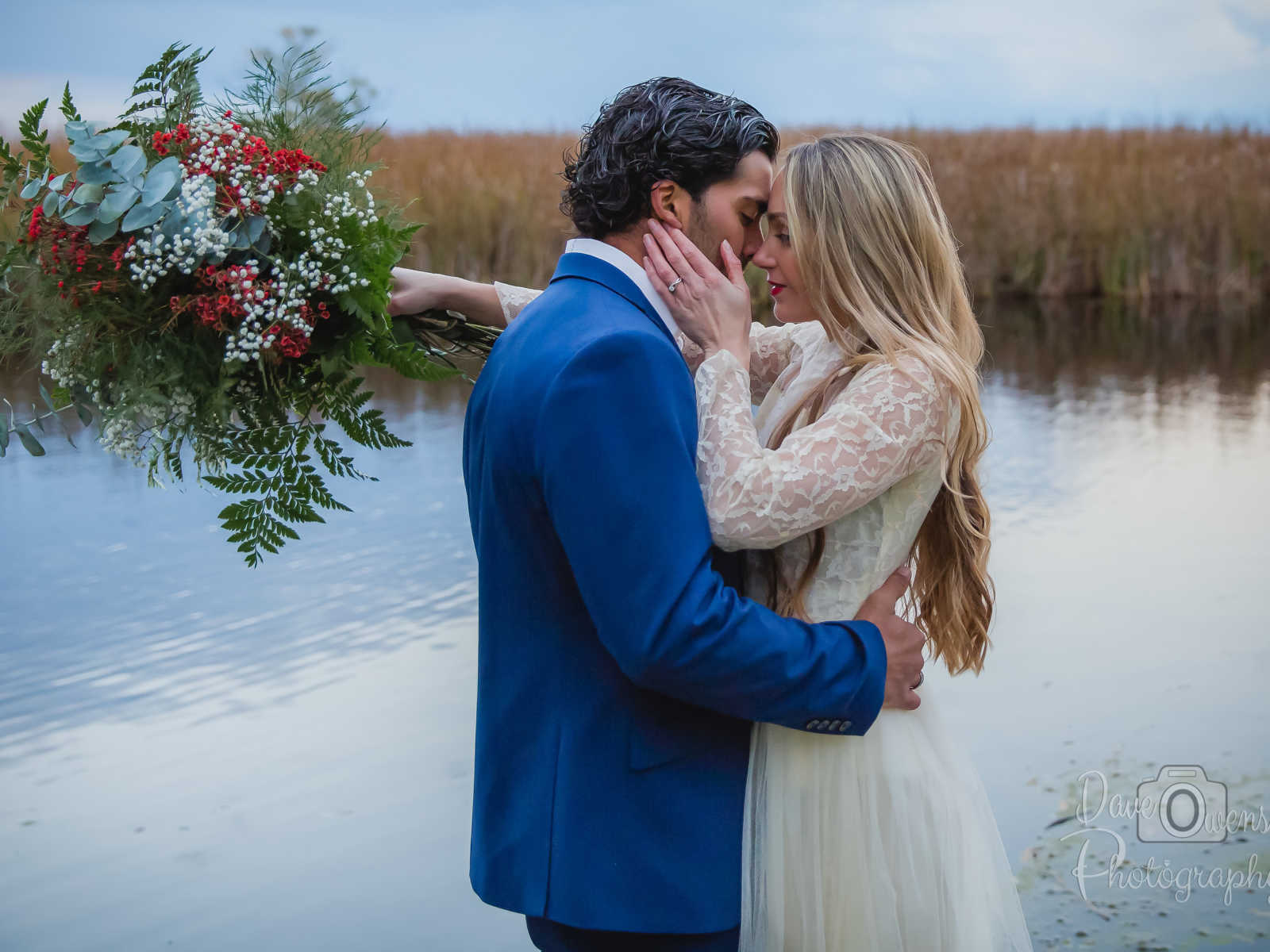 engaged couple about to kiss with water in the background