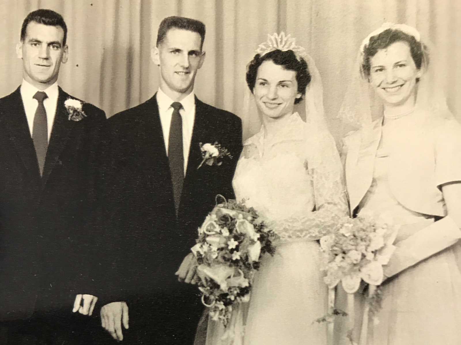 bride and groom smile with another man and woman at their side