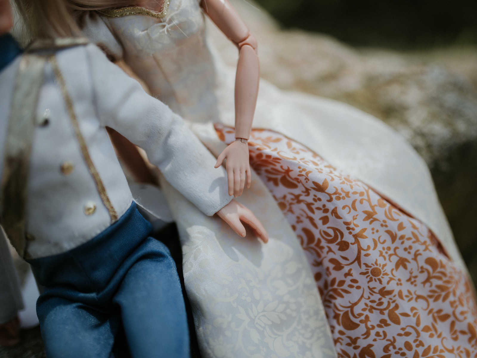 close of of ken and barbie holding hands while sitting