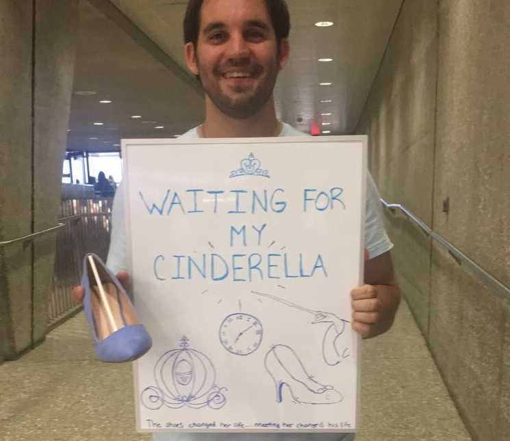 Boyfriend waits for girlfriend at airport with a high heel and sign saying, "waiting for my cinderella"