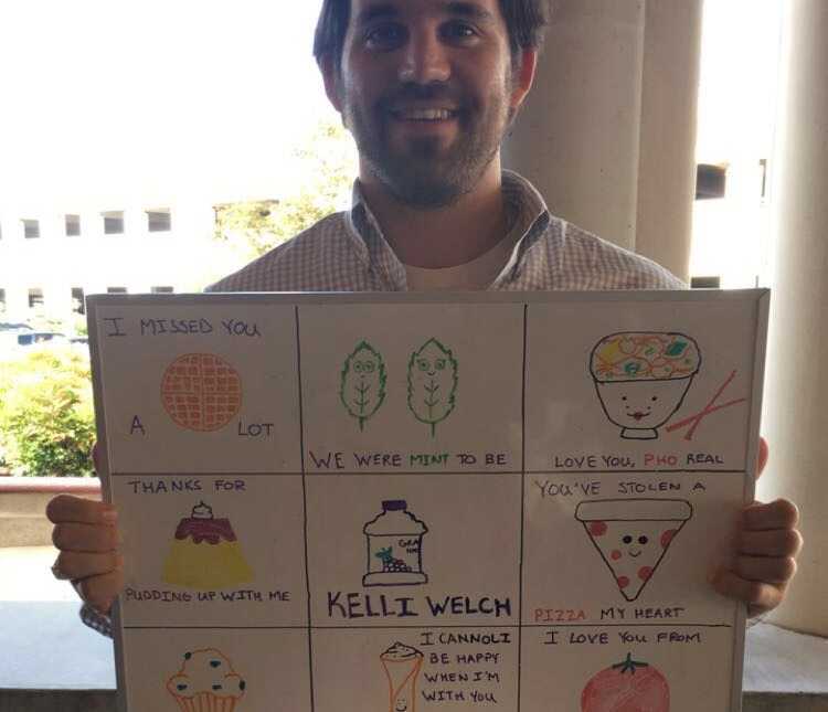 boyfriend makes sign for girlfriend with food puns on it at airport pickup