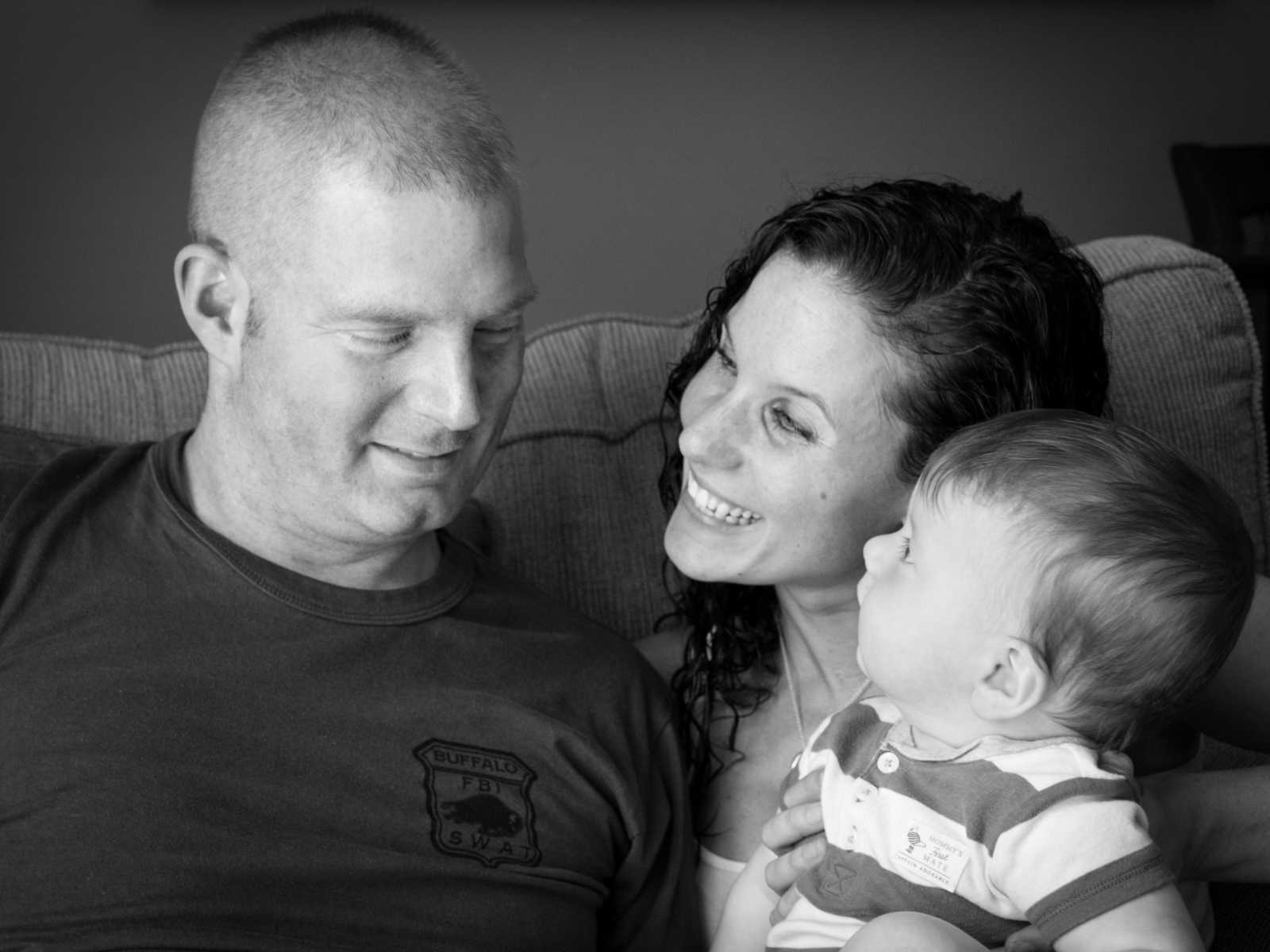 brain cancer patient and his wife sit with son on couch while they all look at each other