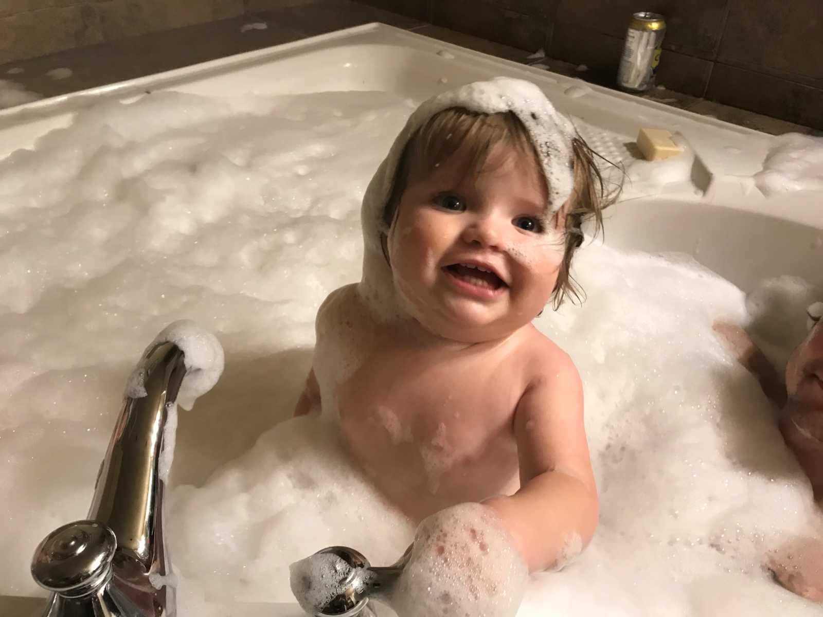 great-great-grandson of oldest man in Canada smiles covered in bubbles in bubble bath