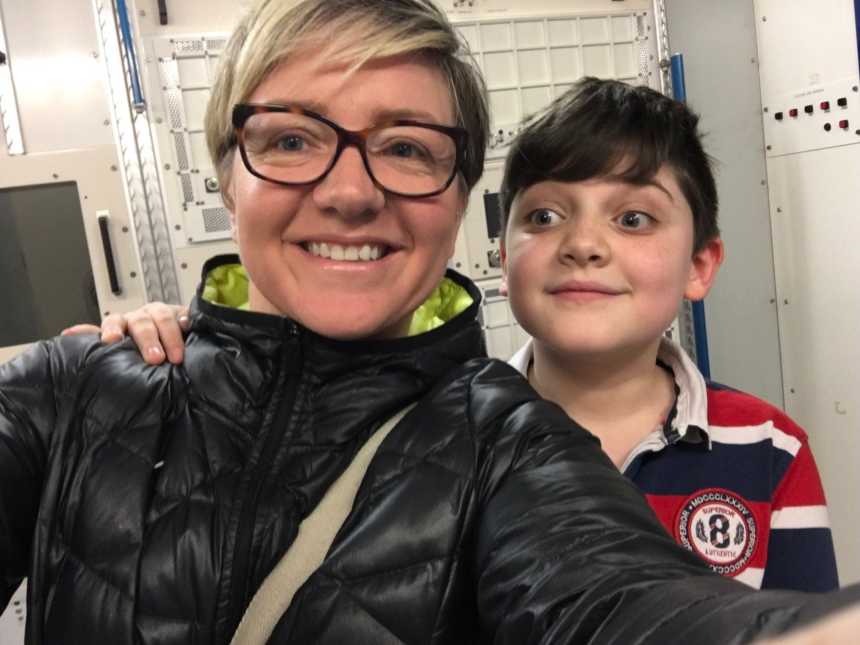 mother with glasses on takes selfie with autistic son