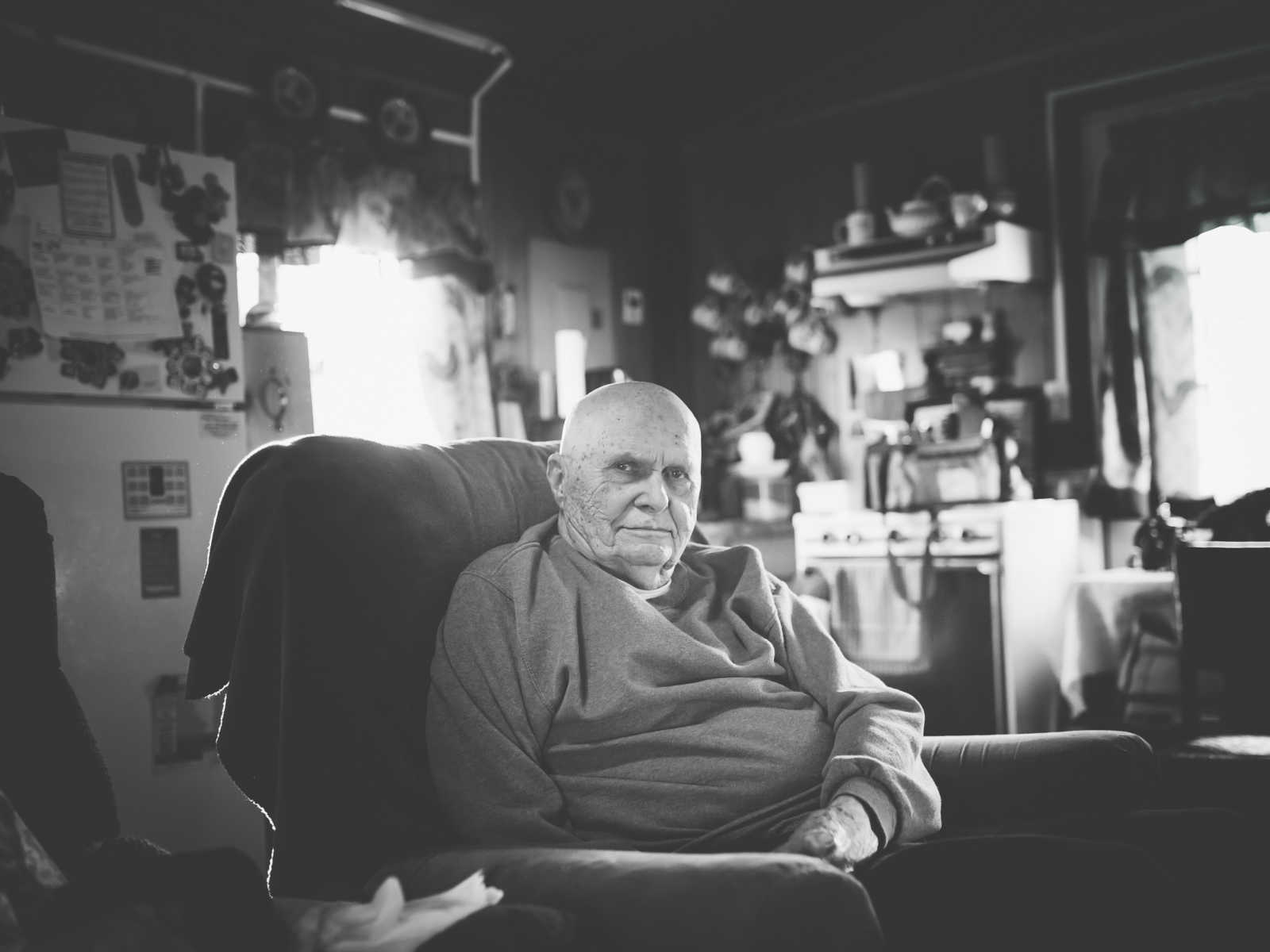 elderly man with a calm look on his face while sitting in chair