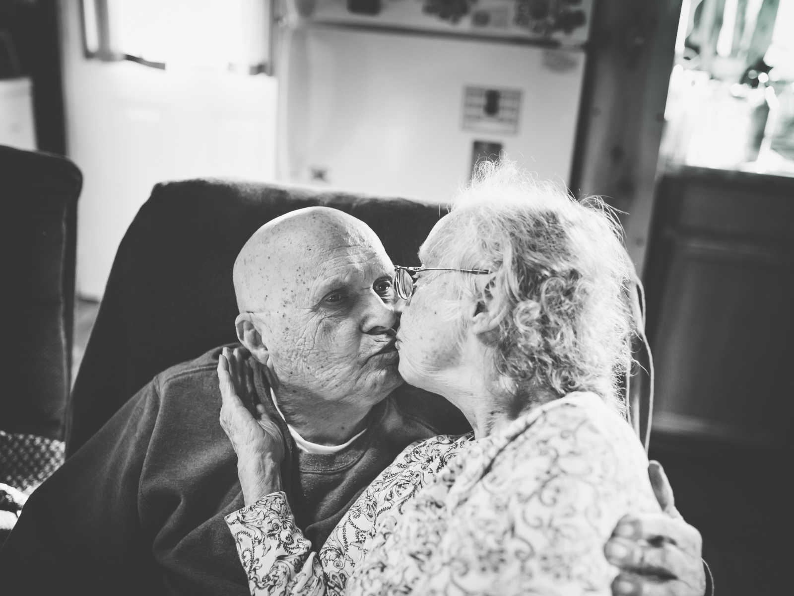 elderly couple gives each other a kiss