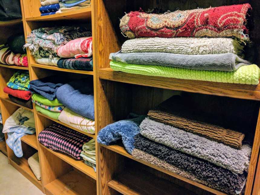 wooden shelves of colorful rugs and blankets