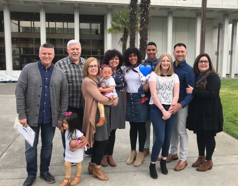 33 year old standing outside of court after being adopted with new family