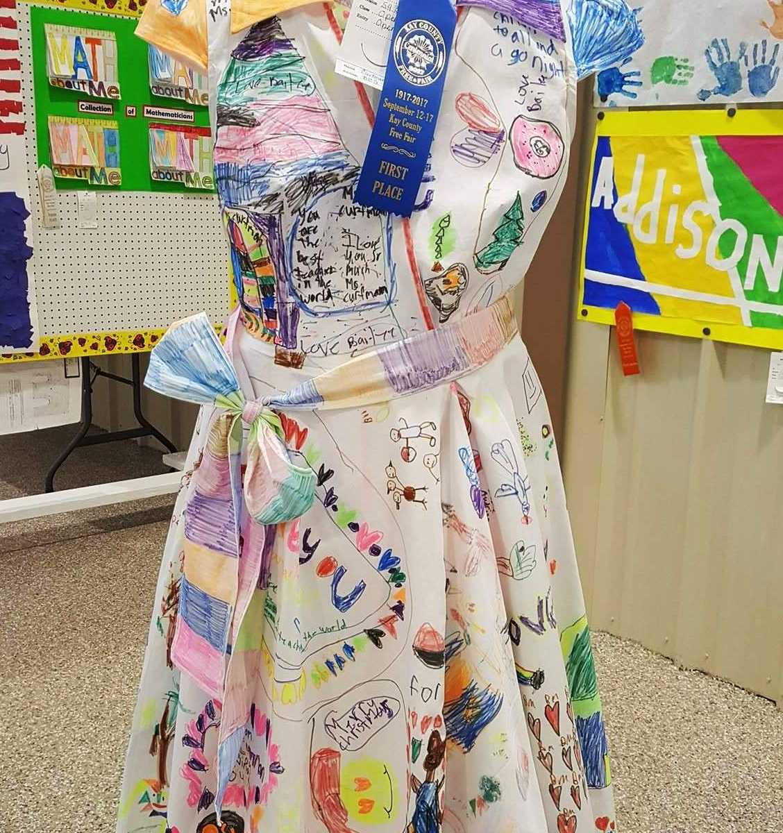 teachers white dress covered in doodles on mannequin with first place blue ribbon on it