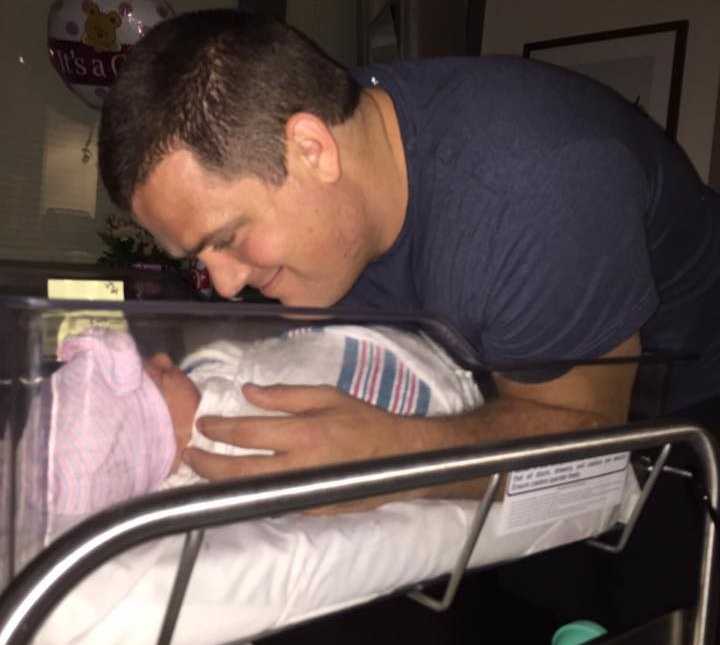 father holds baby girl sleeping in the hospital