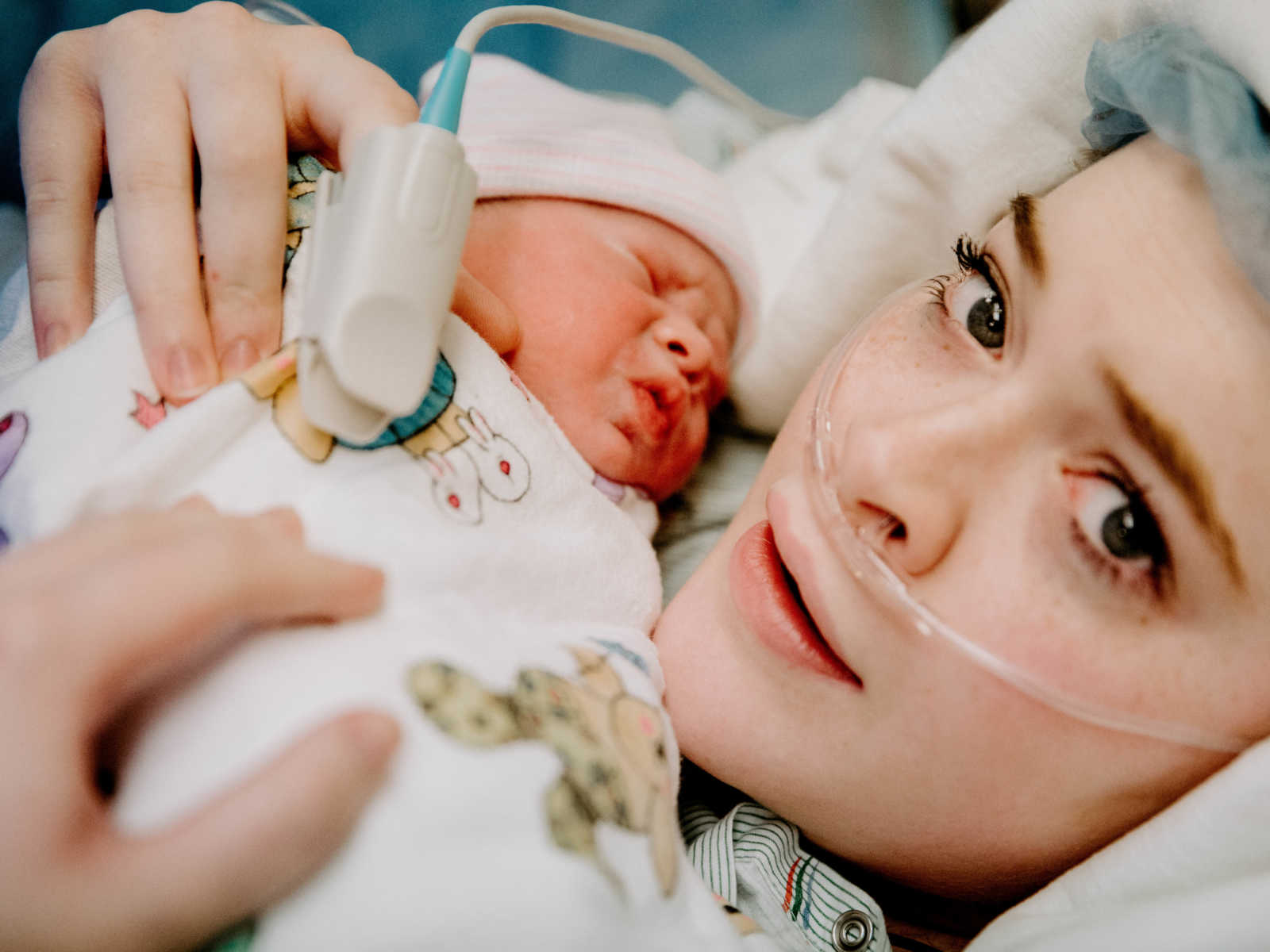 Close up of woman who just had c-section holding her newborn tight to her chest