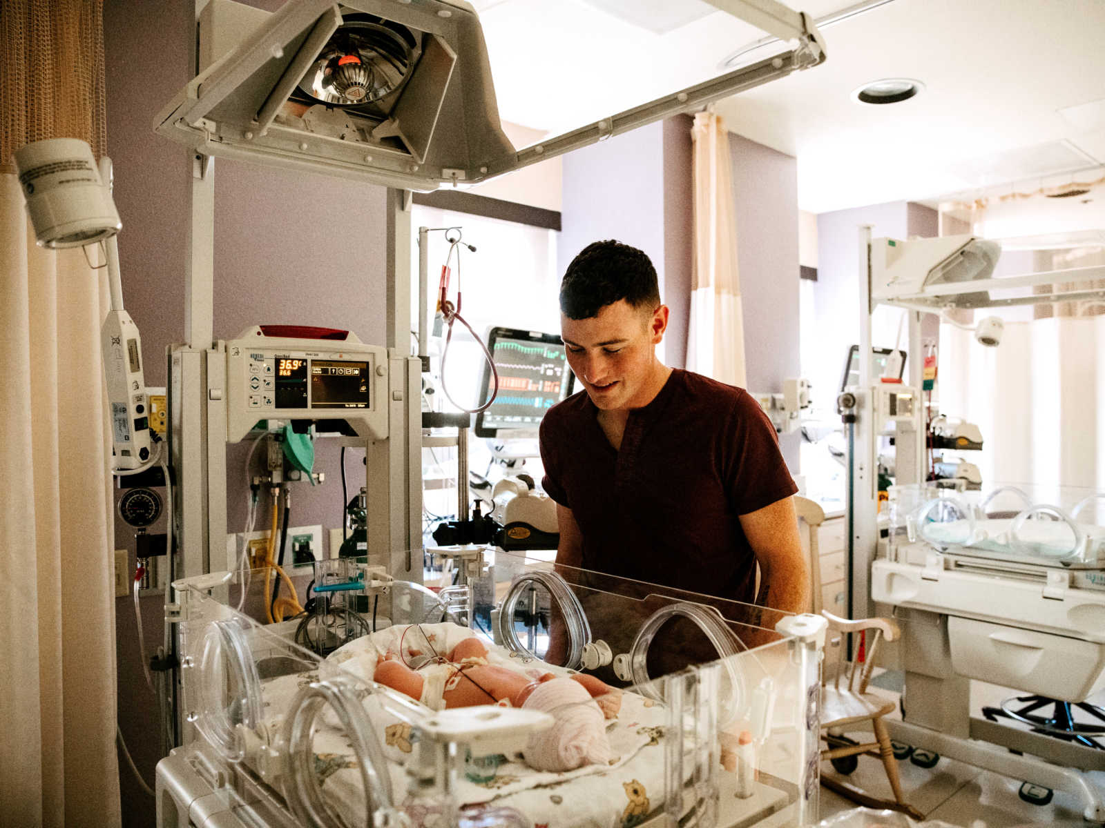 Father of newborn who was birthed via c-section watches baby sleep in NICU