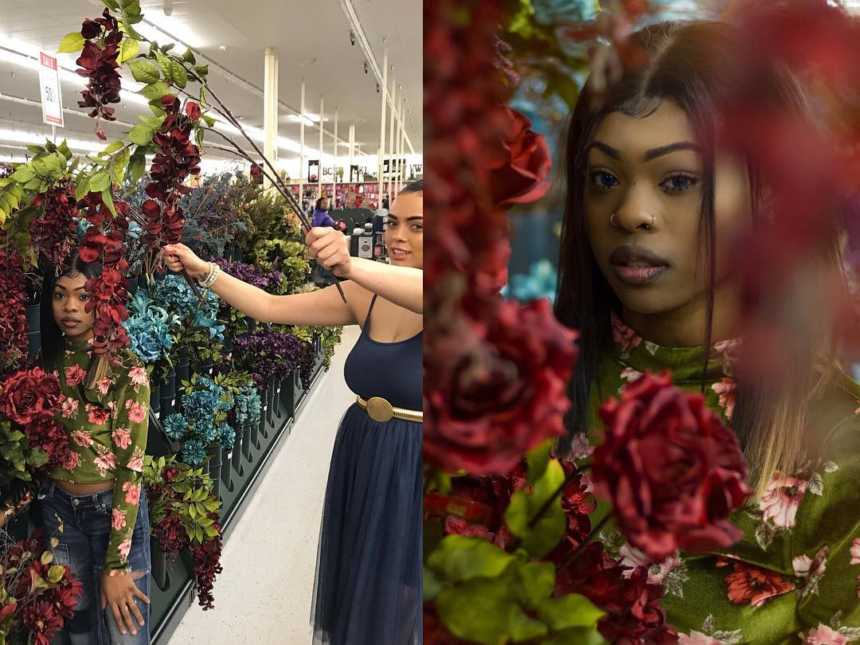 woman standing against a wall of flowers while another woman holds flowers over her to the left and right is after editing