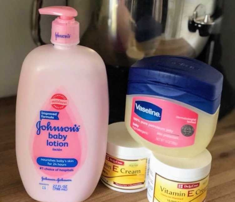 pink johnsons baby lotion on a counter top next two two jars of vitamin E cream with a jar of vaseline on top