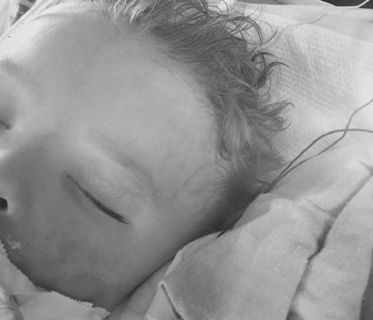 half of toddler boys face sleeping with hair sticking straight up in black and white