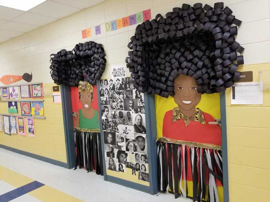 school hallway with black history month decorations of women made of paper on doors and faces of notable african americans