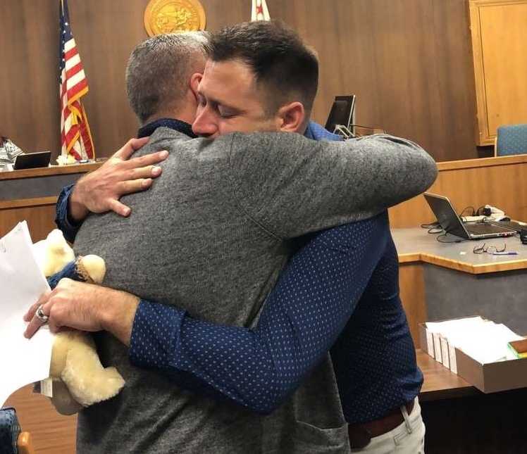33 year old hugs adoptive father in court with teddy bear in hand