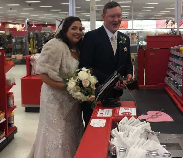 bride and groom are at a target check out and the groom has his wallet open