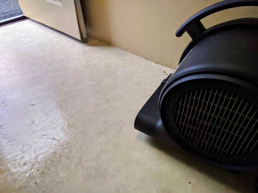 industrial fan on a ceramic tile floor in room with the door open