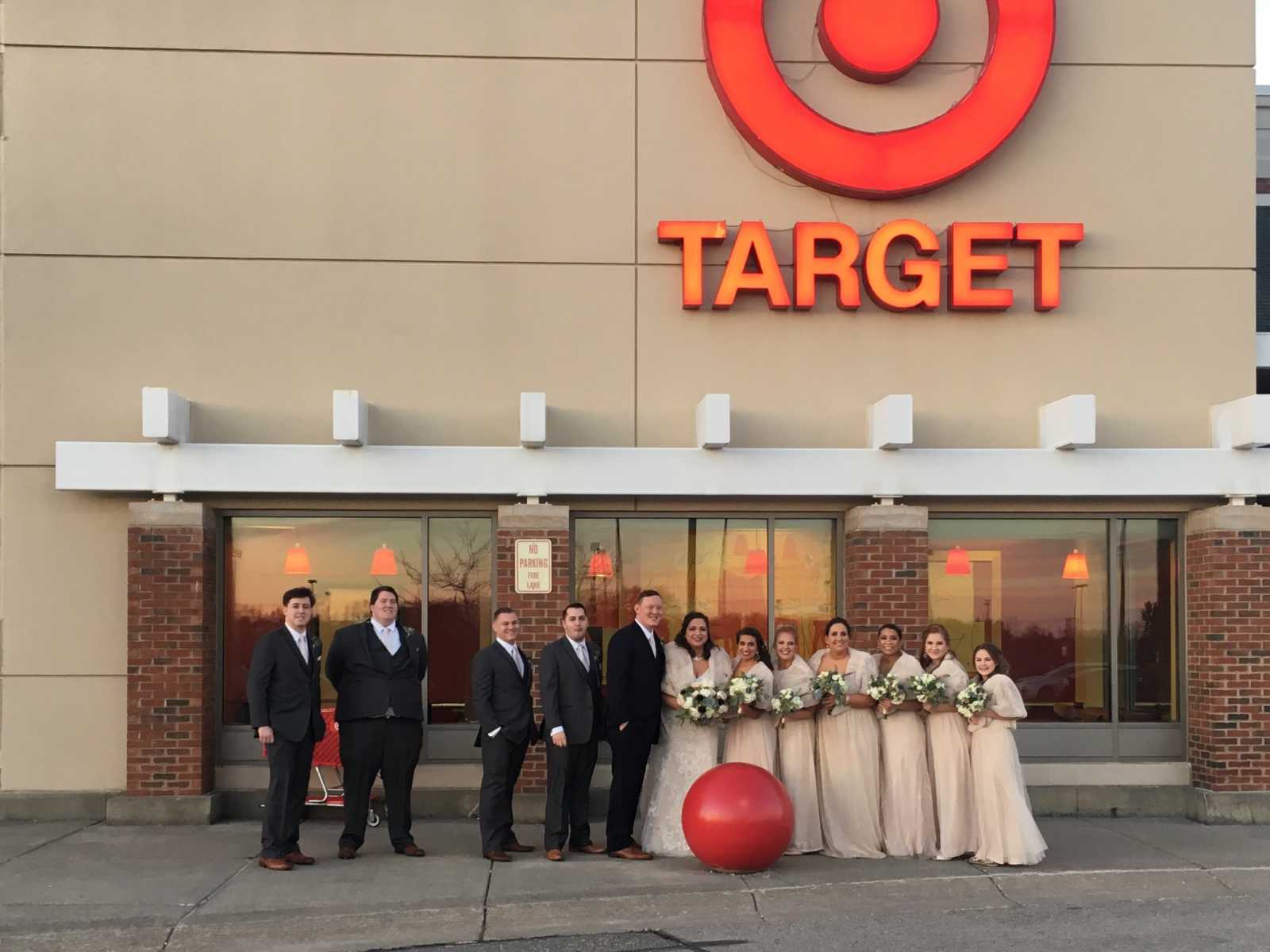 wedding party takes picture outside the front of target with logo above them