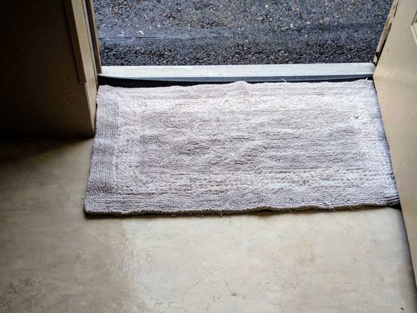 gray floor mat placed in the center of an open door