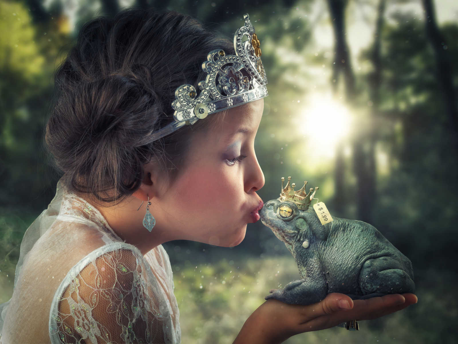 young girl wearing crown holds animated frog with crown on in her hand while giving it a kiss in animated forest