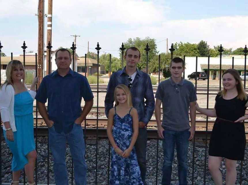 Husband and father diagnosed with pancreatic cancer stands with wife, two sons and daughters in front of train track