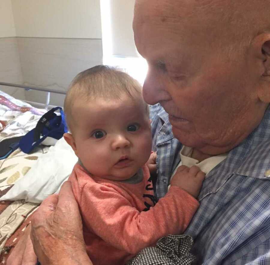 Grandpa gazes at newborn baby