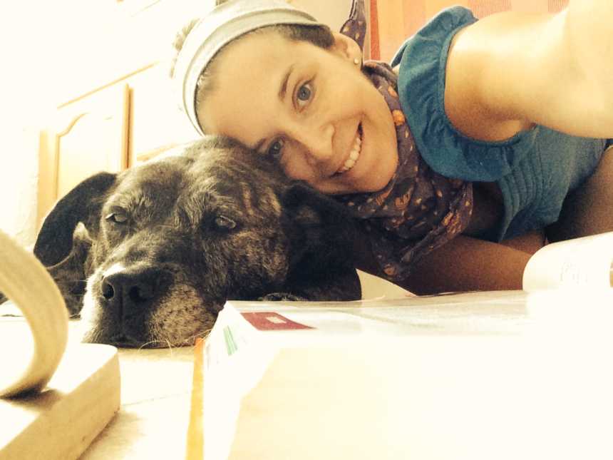 adopted dog lies down while owner leans over to take selfie