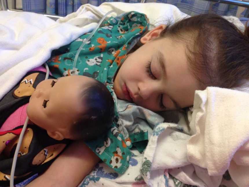 Toddler with rare disease sleeps in hospital bed with american girl doll in her arm