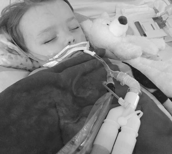 Little boy asleep in hospital after suffering from severe flu like symptoms with pumps up his nose
