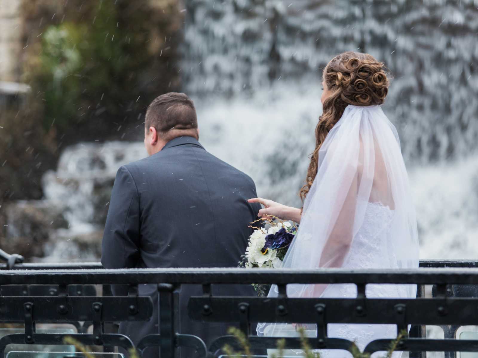 bride taps the grooms back