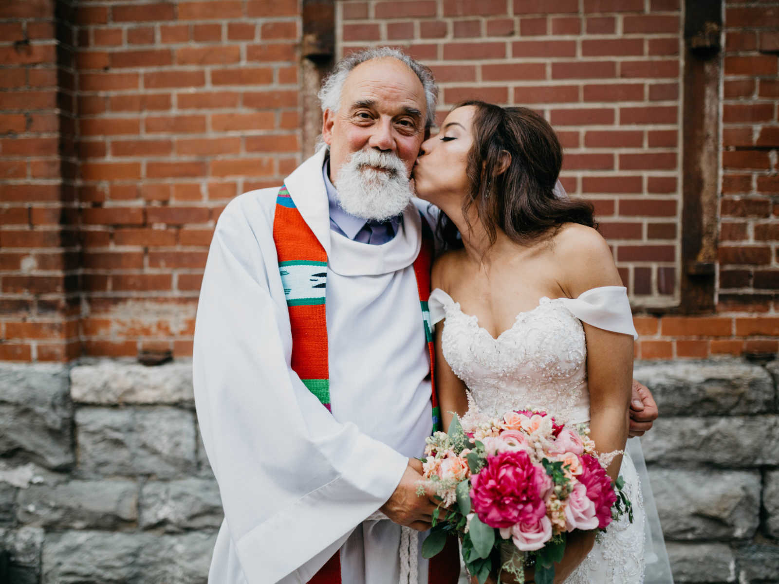 Woman kisses stepdad on the cheek at her wedding where he was officiant
