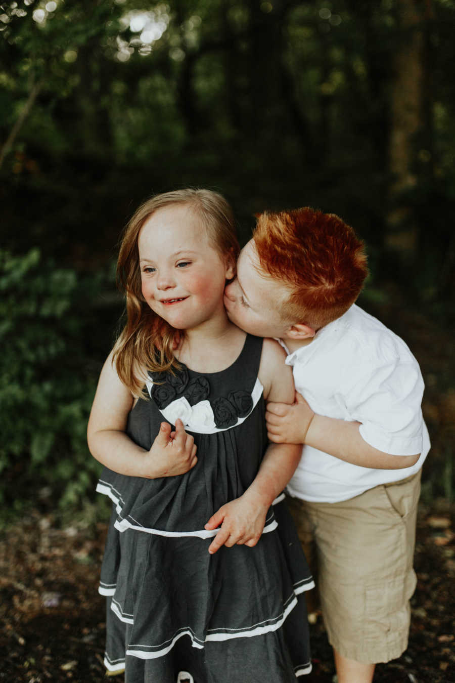 Down syndrome boy kissing the cheek of down syndrome girl