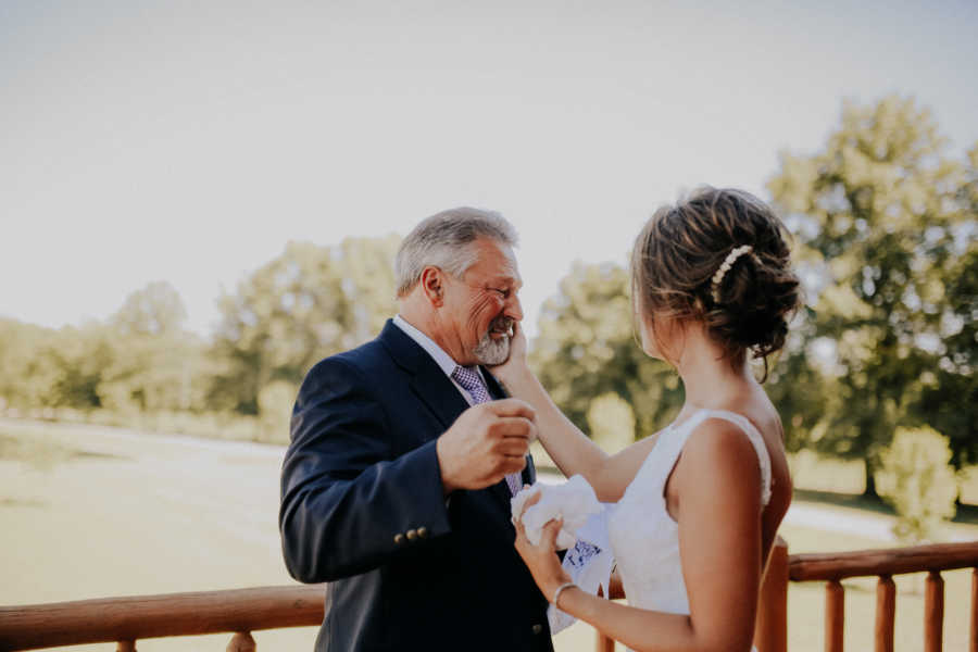 Bride holds face of farmer father as he cries