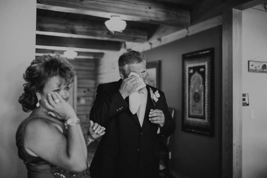 Mother and father of bride cry at wedding reception