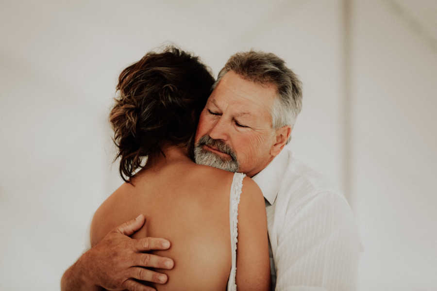 Father and bride hug at wedding reception