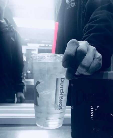 Clear cup in black and white with colored pink straw to symbolize act of kindness