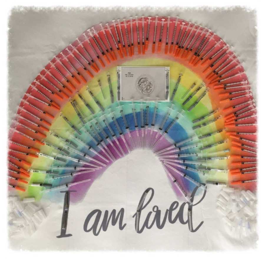 IVF needles arranged in rainbow with sonogram of baby in middle