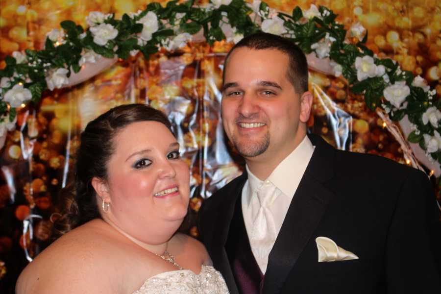 Groom and overweight bride smile at wedding reception