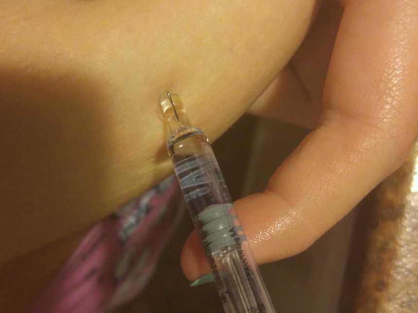 Close up of woman who always wanted to be a mother injecting fertility medication in stomach