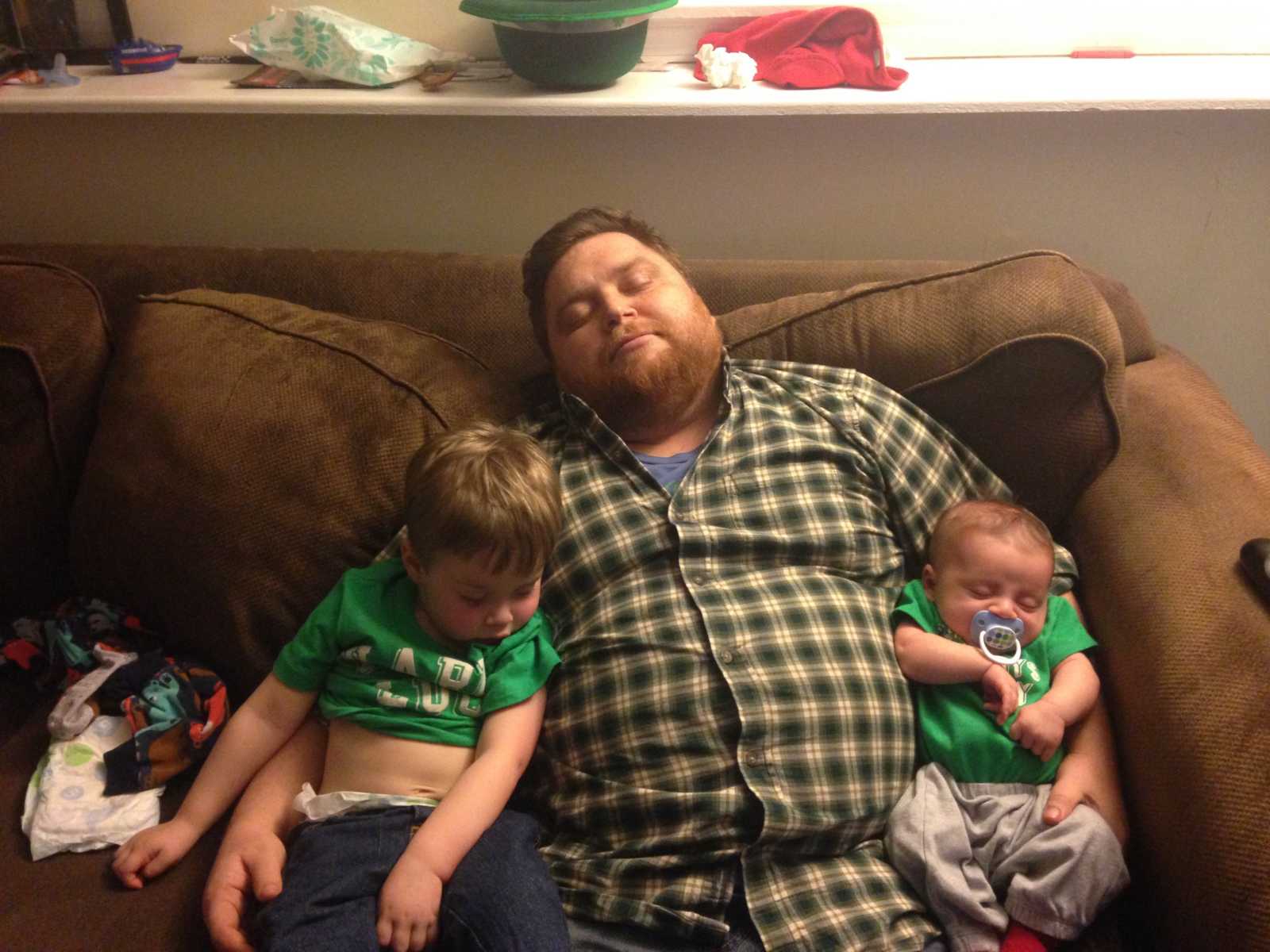 Man who needs kidney transplant when he was younger asleep on couch with sons on either side of him