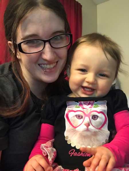Sober woman smiles in selfie with toddler daughter