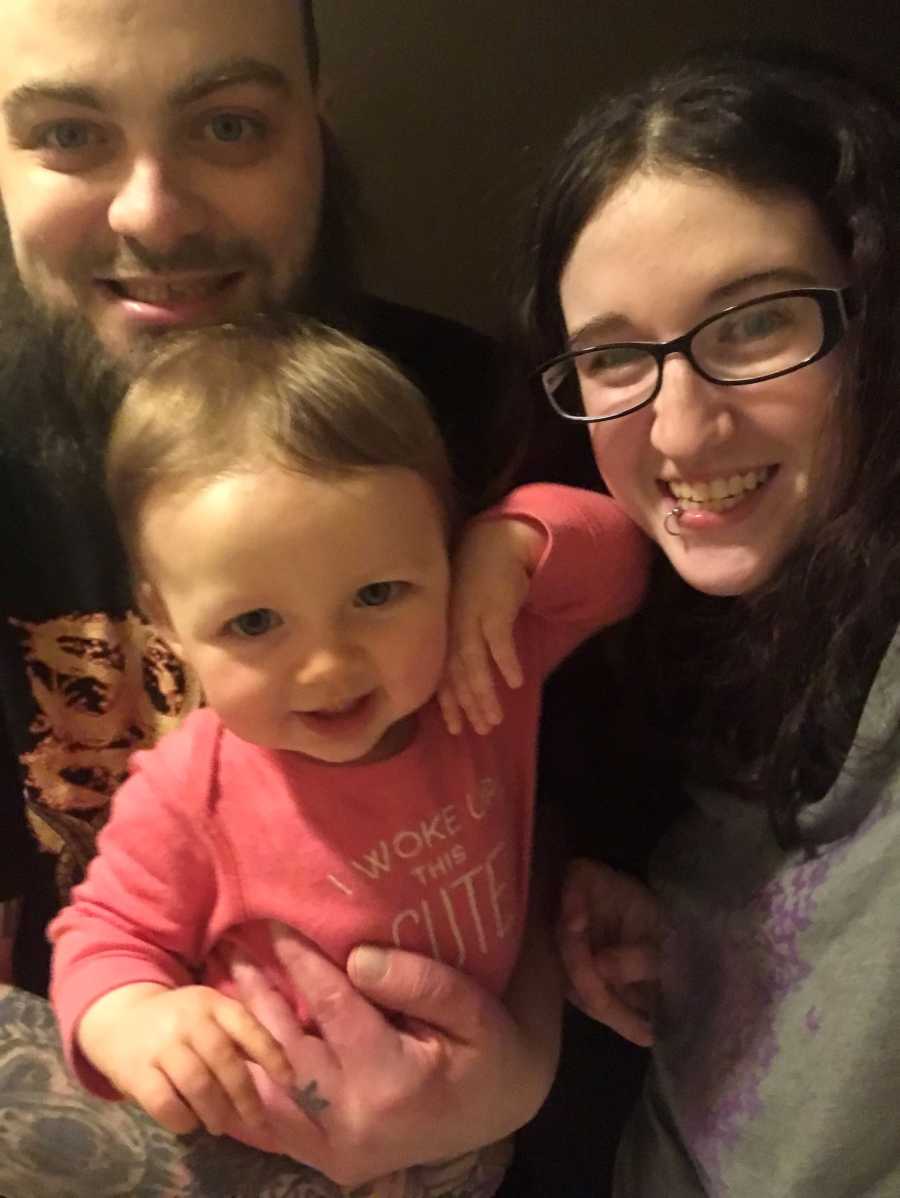 Sober mother and father smile in selfie with toddler daughter