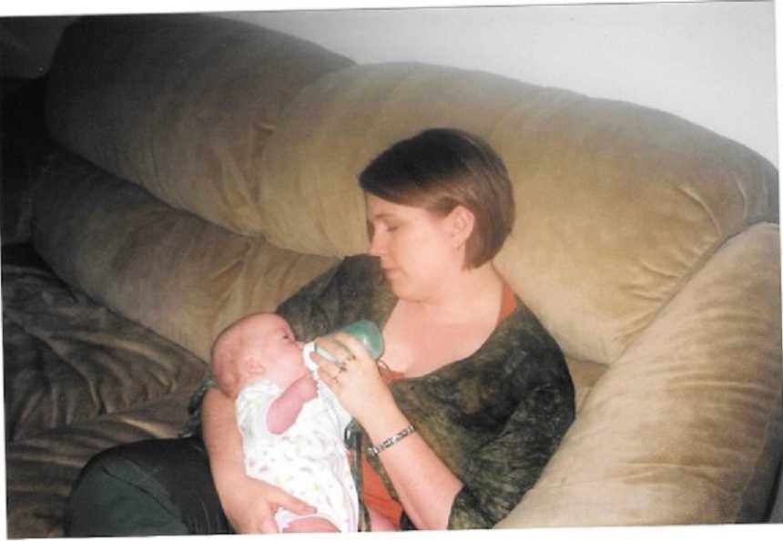 Woman who was a surrogate bottle feeding a baby